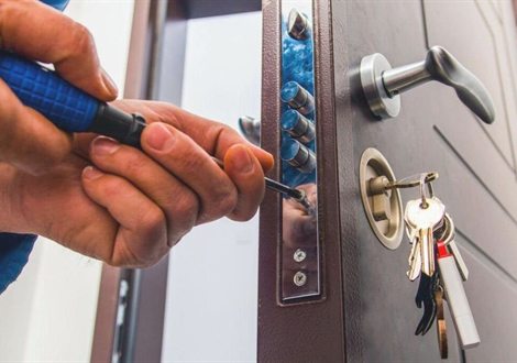 Cerrajero abriendo una puerta en El Raval con herramienta profesional